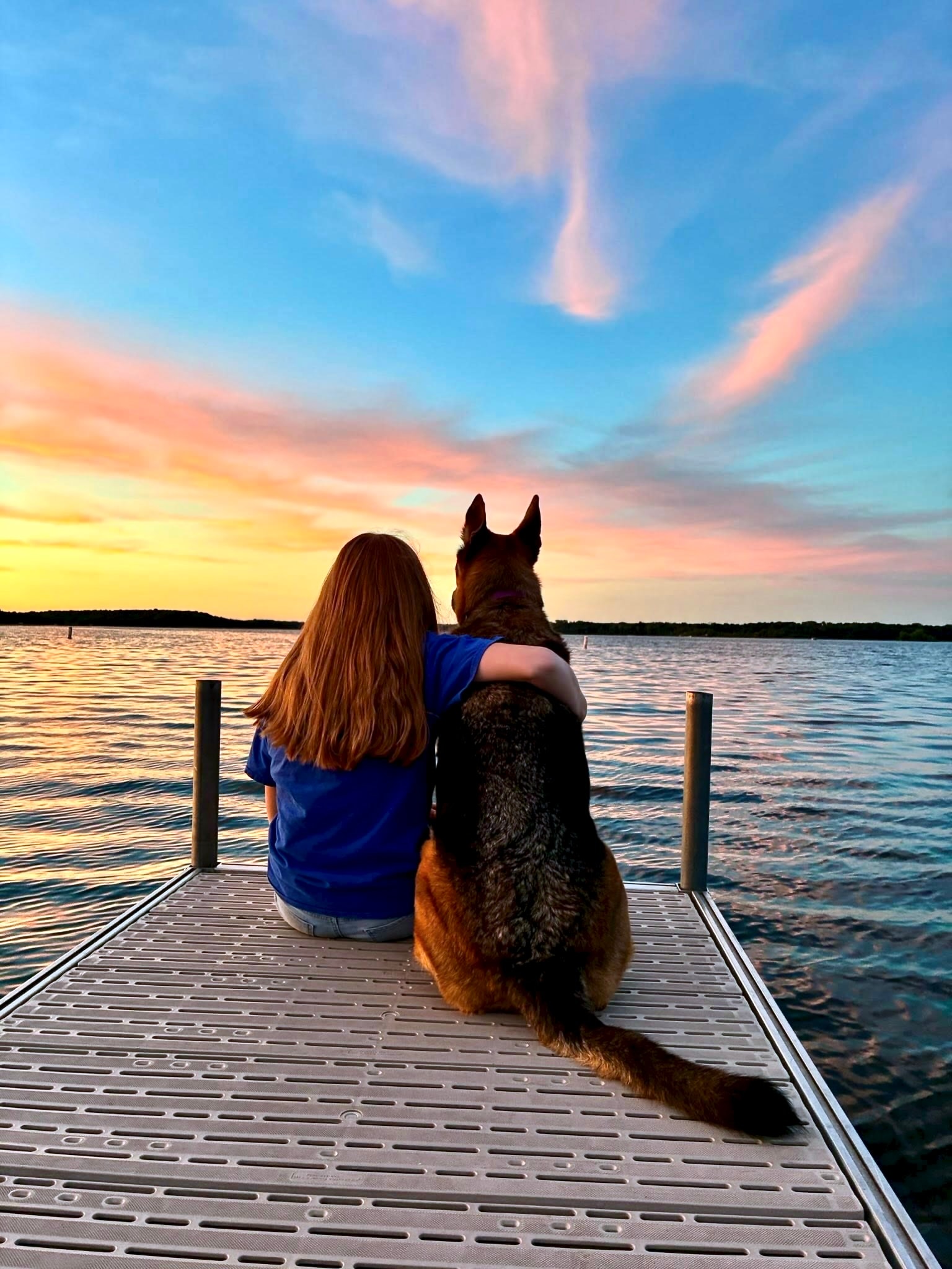 Camp Gratitude child and dog watching sunset on the dock